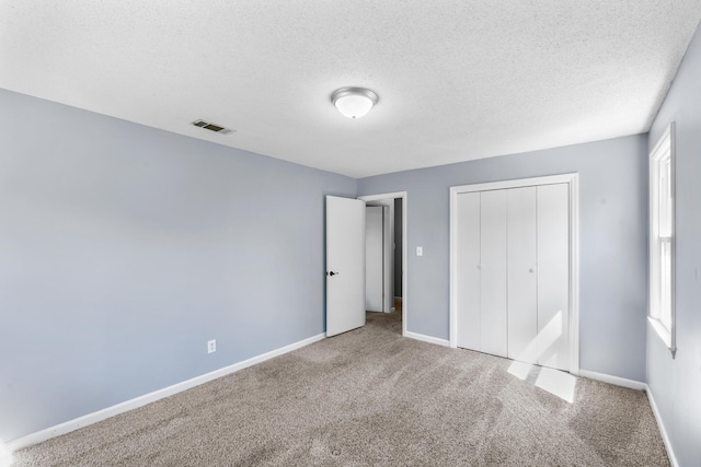 unfurnished bedroom featuring a closet, baseboards, carpet, and visible vents