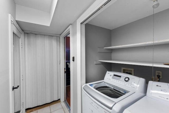 laundry area featuring light tile patterned floors, independent washer and dryer, and laundry area