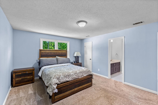 bedroom with ensuite bathroom, carpet, a textured ceiling, visible vents, and baseboards