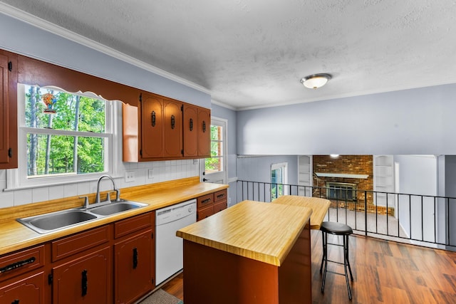 kitchen featuring white dishwasher, dark wood-style flooring, a textured ceiling, and a sink