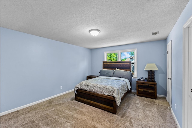 bedroom featuring visible vents, a textured ceiling, baseboards, and carpet floors