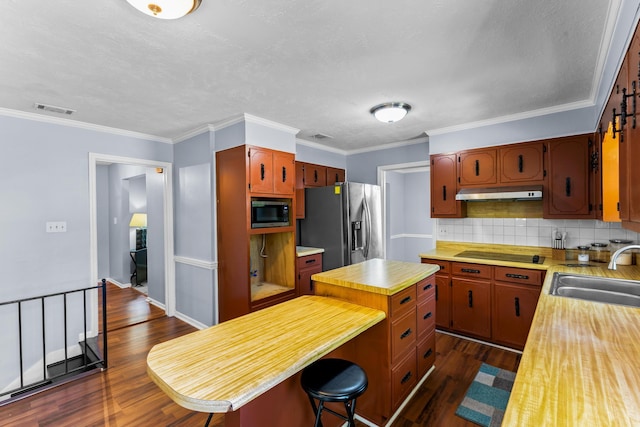 kitchen with visible vents, under cabinet range hood, dark wood-style flooring, a sink, and stainless steel appliances