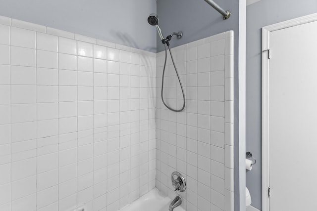 bathroom with bathtub / shower combination and toilet