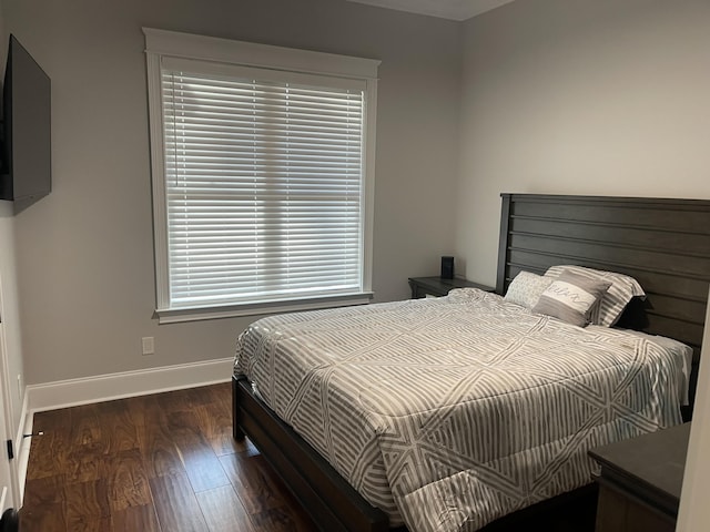 bedroom with dark hardwood / wood-style floors