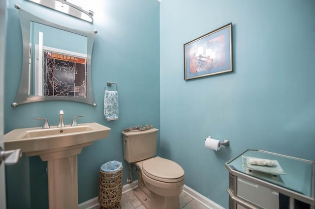 bathroom with sink, toilet, and tile patterned flooring