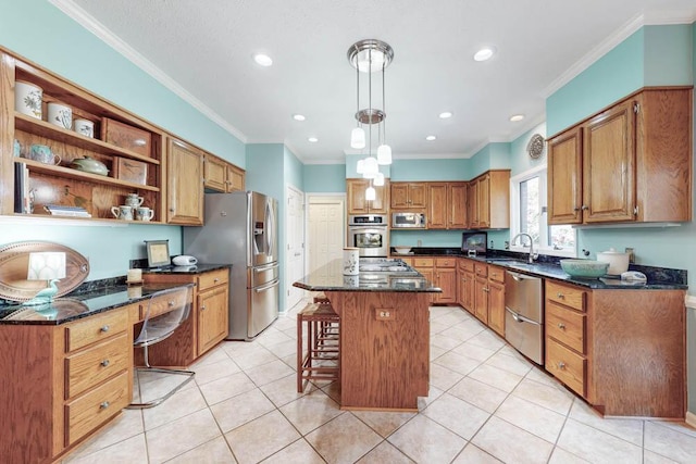 kitchen with sink, a breakfast bar area, appliances with stainless steel finishes, a center island, and decorative light fixtures