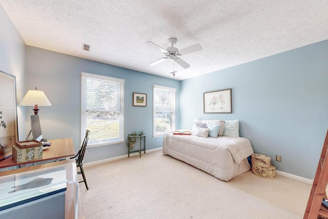 bedroom featuring ceiling fan, carpet, and a textured ceiling