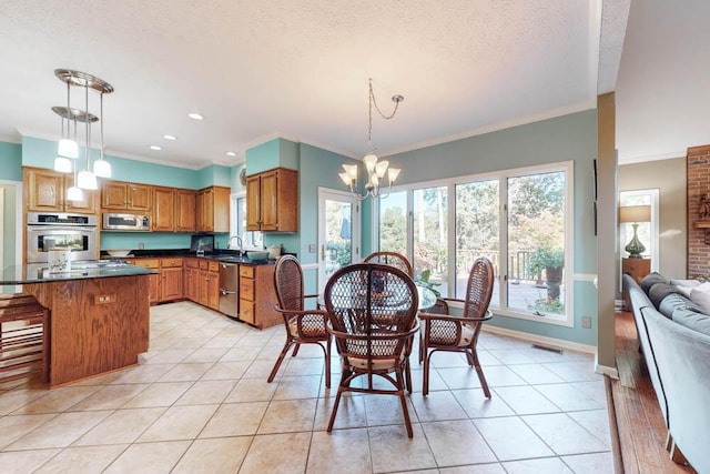 tiled dining area with crown molding, sink, a textured ceiling, and an inviting chandelier