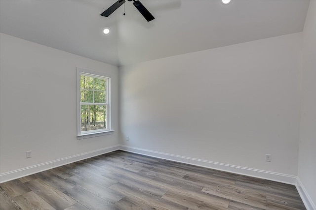 empty room featuring hardwood / wood-style flooring, vaulted ceiling, and ceiling fan