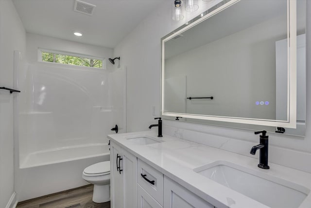 full bathroom with  shower combination, wood-type flooring, vanity, and toilet