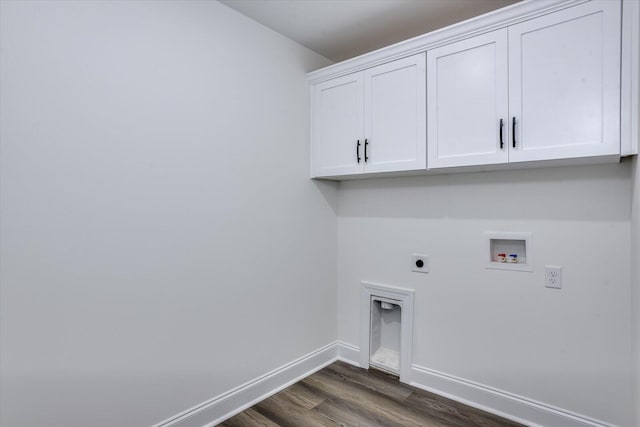 washroom featuring electric dryer hookup, hookup for a washing machine, dark wood-type flooring, and cabinets