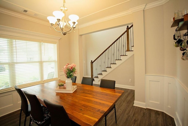 1144 George W Crawford Dr, Augusta, GA 30909 - dining space with a chandelier, stairs, dark wood-type flooring, crown molding, and a wainscoted wall