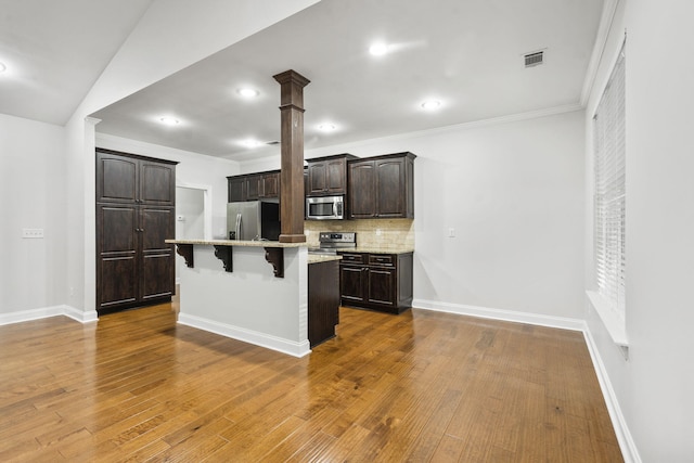 4752 Storey Mill Rd, Hephzibah, GA 30815 - kitchen featuring stainless steel appliances, a breakfast bar, dark brown cabinets, tasteful backsplash, and a center island