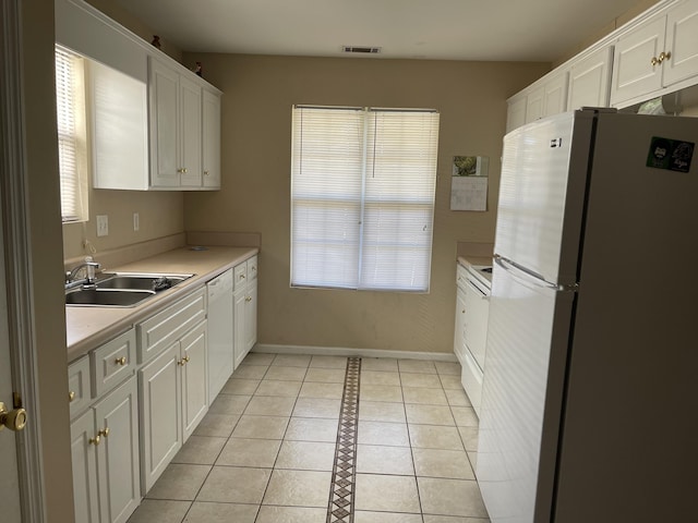1420 Perry Ave, Augusta, GA 30901 - kitchen with freestanding refrigerator, a sink, light tile patterned floors, and white cabinetry