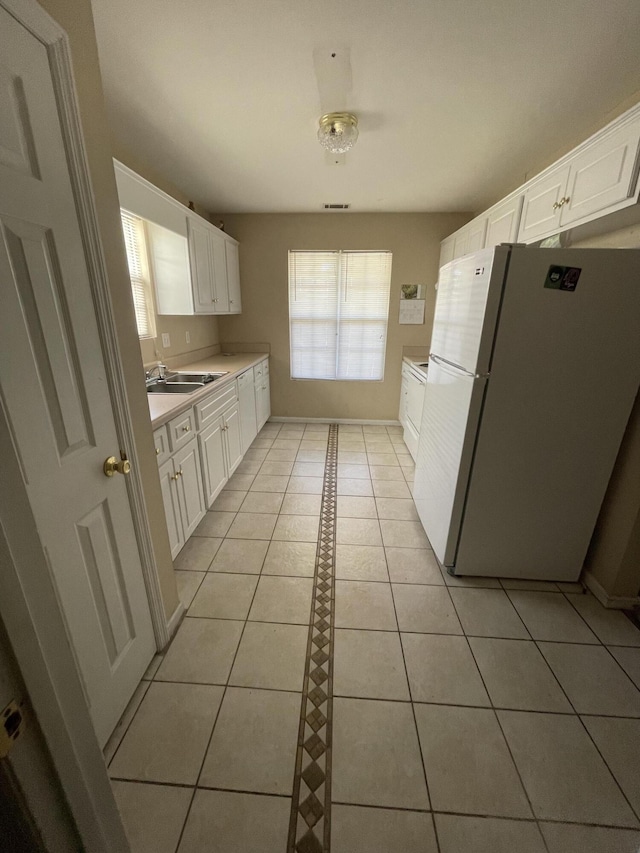 1420 Perry Ave, Augusta, GA 30901 - kitchen featuring freestanding refrigerator, light countertops, white cabinetry, light tile patterned flooring, and a sink