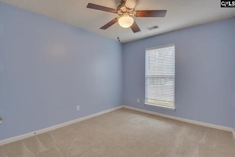 carpeted spare room with ceiling fan