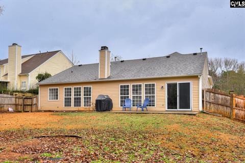 rear view of house featuring a yard