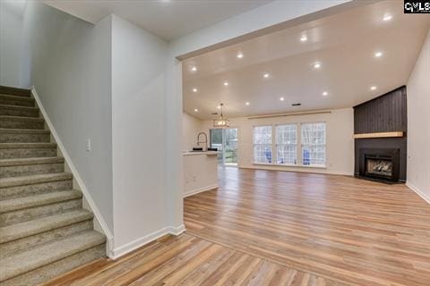 unfurnished living room featuring a large fireplace and light hardwood / wood-style floors