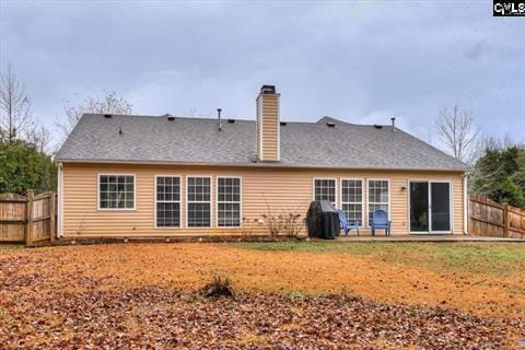 back of house featuring a lawn