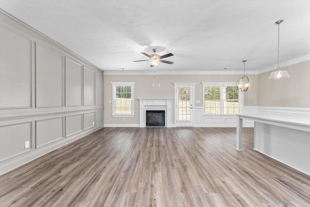 5921 Big Pond Trl, Grovetown, GA 30813 - unfurnished living room with a decorative wall, a ceiling fan, ornamental molding, a fireplace, and wood finished floors