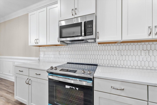 5921 Big Pond Trl, Grovetown, GA 30813 - kitchen featuring appliances with stainless steel finishes, crown molding, light countertops, white cabinetry, and light wood-style floors