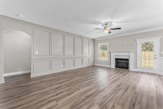 5921 Big Pond Trl, Grovetown, GA 30813 - unfurnished living room with ceiling fan, wood finished floors, a brick fireplace, ornamental molding, and arched walkways