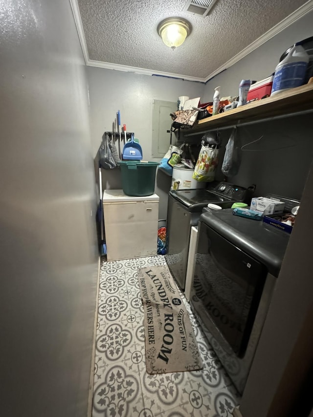 laundry area with a textured ceiling, separate washer and dryer, and crown molding