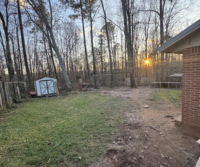 yard at dusk with a trampoline and a storage shed