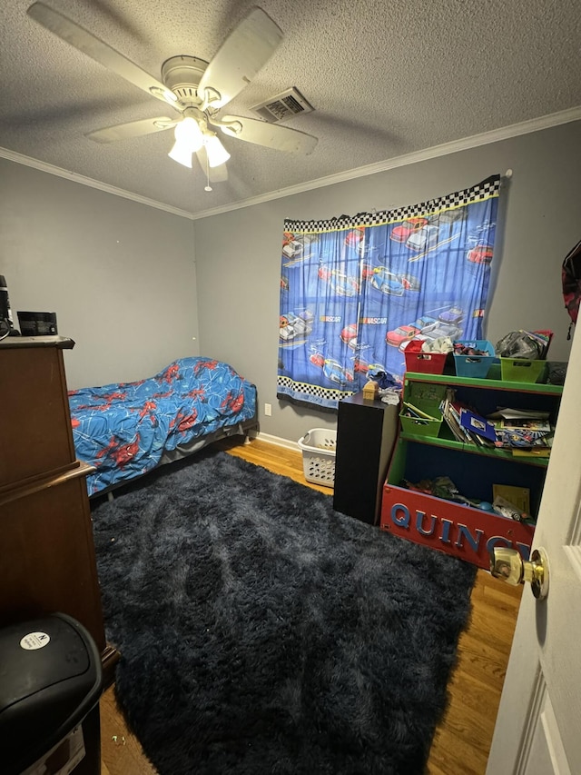 bedroom featuring a textured ceiling, ceiling fan, and ornamental molding