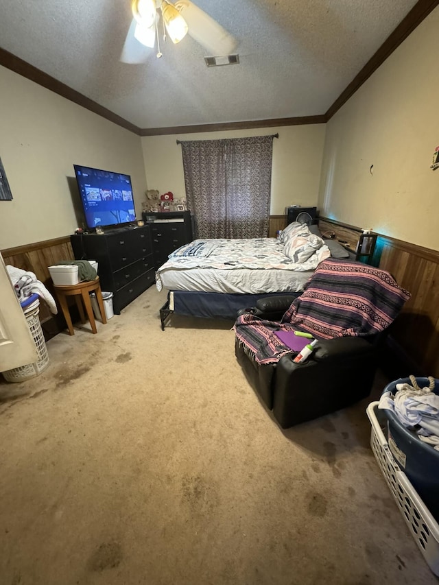 bedroom with ceiling fan, carpet floors, a textured ceiling, and ornamental molding