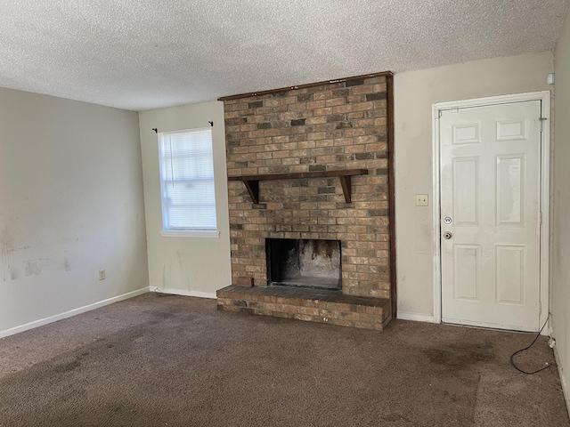 unfurnished living room with carpet floors, a brick fireplace, baseboards, and a textured ceiling