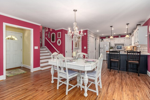 1300 Concord Ave, North Augusta, SC 29841 - dining area with a chandelier, stairs, baseboards, light wood-style floors, and crown molding