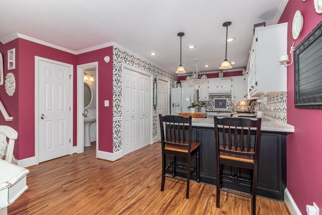 1300 Concord Ave, North Augusta, SC 29841 - kitchen featuring white fridge with ice dispenser, baseboards, white cabinetry, decorative backsplash, and a peninsula