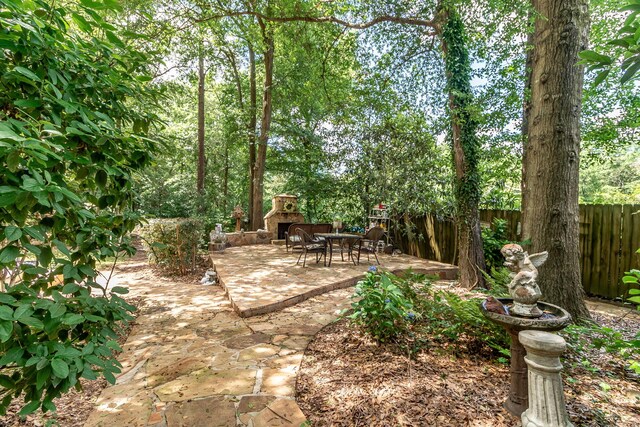 1300 Concord Ave, North Augusta, SC 29841 - view of yard featuring an outdoor stone fireplace, a patio, and fence