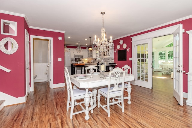 1300 Concord Ave, North Augusta, SC 29841 - dining room featuring crown molding, light wood-type flooring, a chandelier, and baseboards