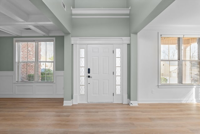 foyer with crown molding, plenty of natural light, beam ceiling, and light hardwood / wood-style flooring