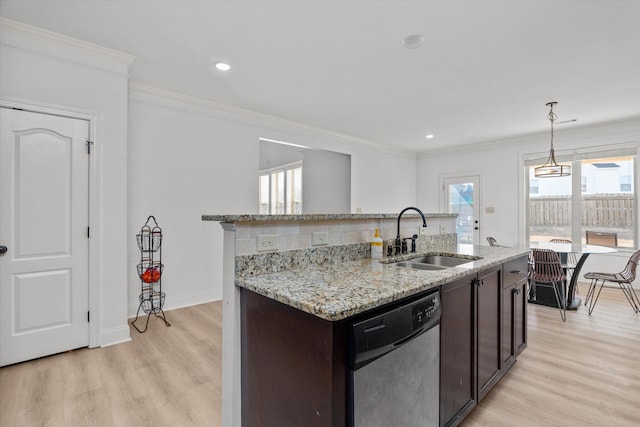 kitchen featuring sink, decorative light fixtures, dark brown cabinets, a center island with sink, and dishwasher