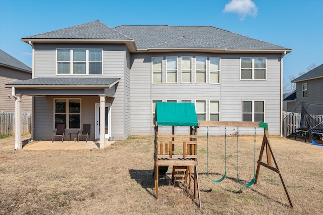 rear view of house with a yard, a playground, and a patio