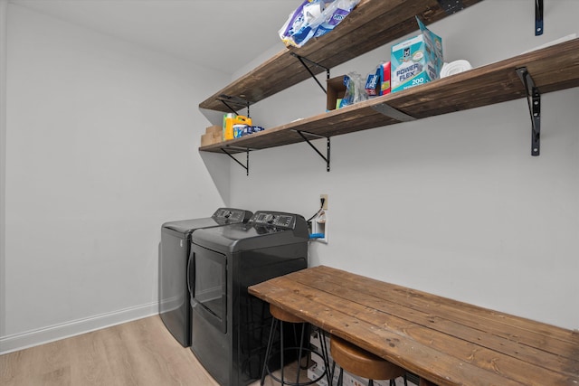 laundry area featuring separate washer and dryer and light hardwood / wood-style floors