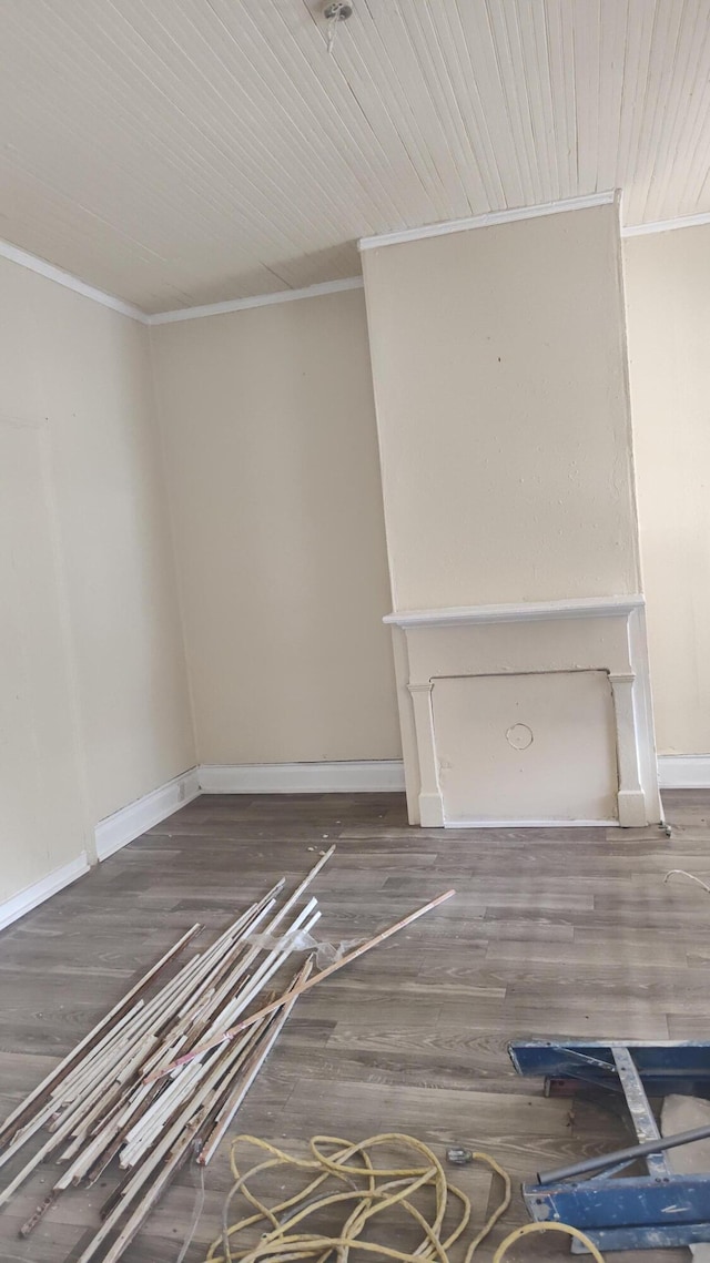 unfurnished living room featuring dark hardwood / wood-style flooring and ornamental molding