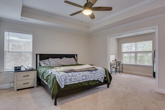 carpeted bedroom with ceiling fan, crown molding, multiple windows, and a raised ceiling