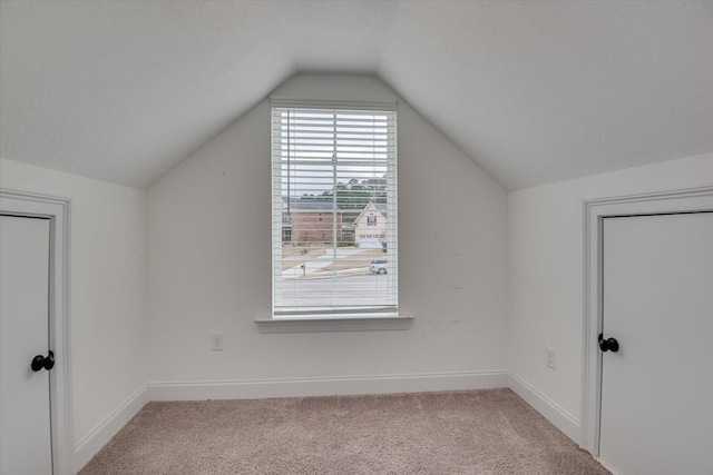 additional living space with lofted ceiling and light carpet