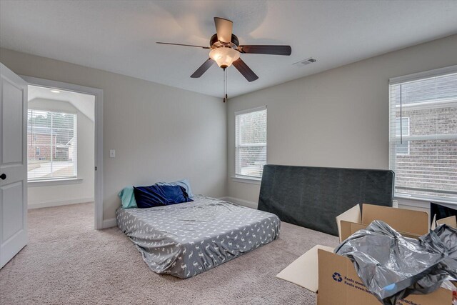 carpeted bedroom with ceiling fan and multiple windows