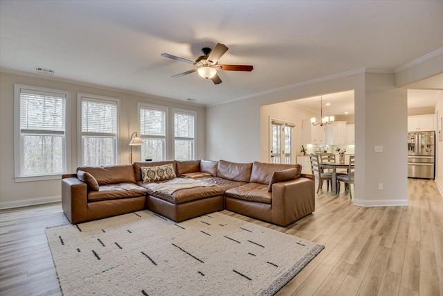 living room with ceiling fan with notable chandelier, crown molding, and light hardwood / wood-style flooring