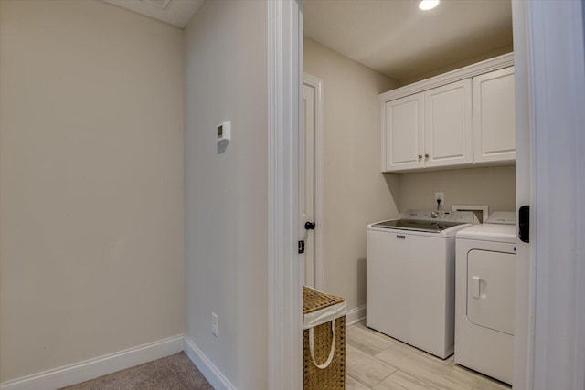 washroom featuring washer and dryer and cabinets