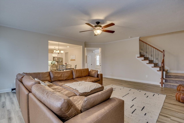 living room with light hardwood / wood-style floors, crown molding, and ceiling fan with notable chandelier