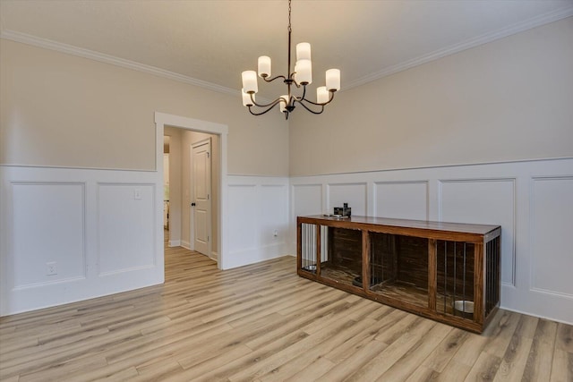 dining space featuring an inviting chandelier, light hardwood / wood-style floors, and crown molding