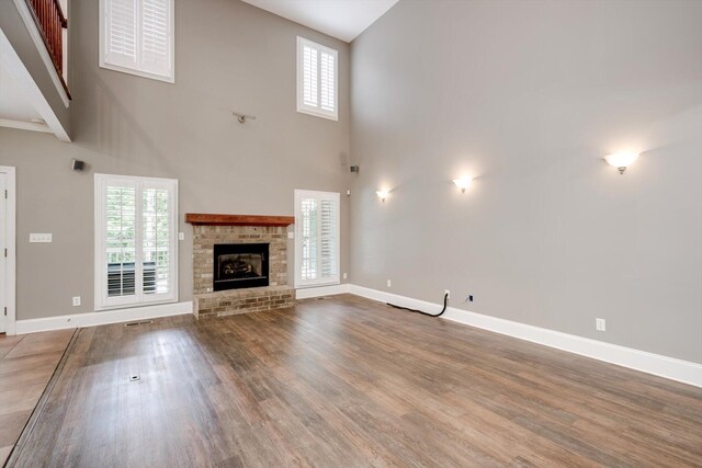 2288 William Few Pkwy, Evans, GA 30809 - unfurnished living room featuring a high ceiling, wood finished floors, plenty of natural light, and baseboards