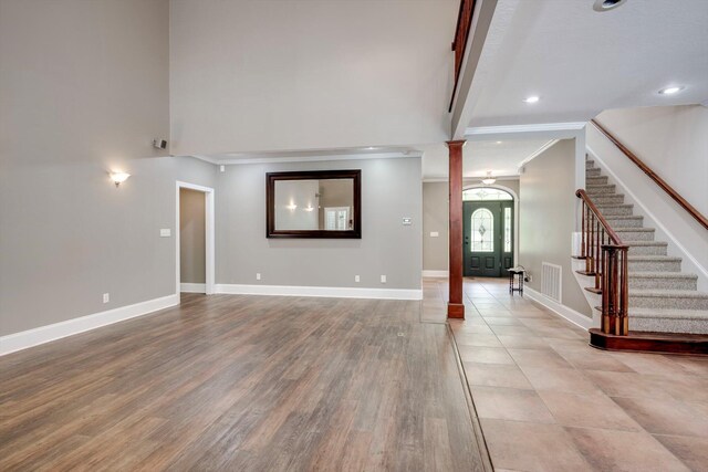2288 William Few Pkwy, Evans, GA 30809 - unfurnished living room with ornate columns, stairs, crown molding, baseboards, and recessed lighting