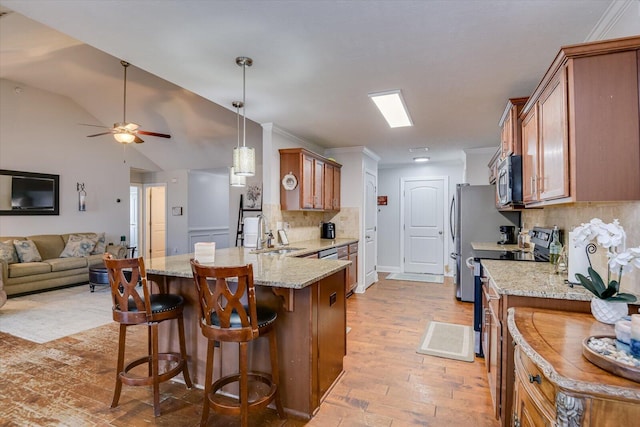 kitchen with decorative backsplash, appliances with stainless steel finishes, sink, and a breakfast bar area